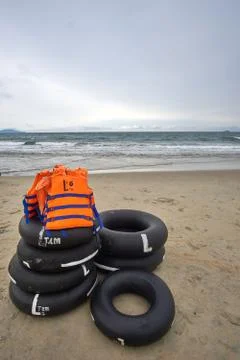 Stormy evening at the beach with dramatic clouds and waves. With life jackets Stock Photos