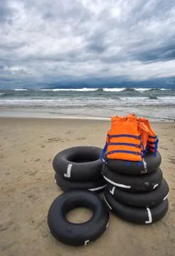 Stormy evening at the beach with dramatic clouds and waves. With life jackets Stock Photos
