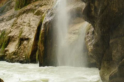 A stormy falling waterfall and a river in the Chegem gorge Stock Photos