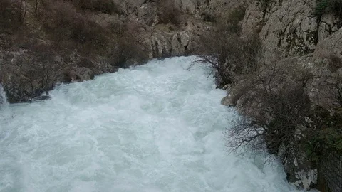 A stormy mountain river flows widely among the mountains Video stock 74733539