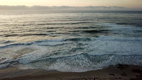 A stormy ocean aerial shot pulls back to reveal beachfront homes Stock Footage 84774839