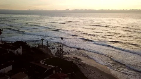 A stormy ocean and rocky point with beachfront homes seen from a drone Stock Footage 84775053