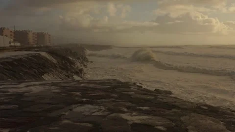 Stormy Ocean Waves Crash at Sunset: Powerful Surf on a Cloudy Beach Video stock 288686250