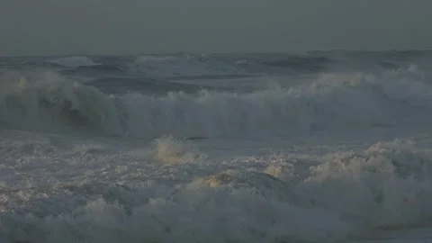 Stormy Ocean Waves Crash at Sunset: Powerful Surf on a Cloudy Beach Video stock 288686752