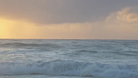 Stormy Ocean Waves Crash at Sunset: Powerful Surf on a Cloudy Beach Video stock 288686922