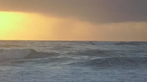 Stormy Ocean Waves Crash at Sunset: Powerful Surf on a Cloudy Beach Video stock 288686984