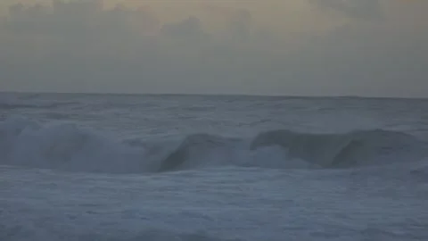 Stormy Ocean Waves Crash at Sunset: Powerful Surf on a Cloudy Beach Video stock 288687162