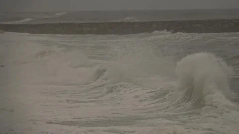 Stormy Ocean Waves Crash at Sunset: Powerful Surf on a Cloudy Beach Video stock 288687178