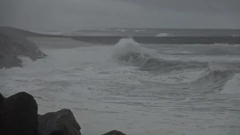 Stormy Ocean Waves Crash at Sunset: Powerful Surf on a Cloudy Beach Video stock 288687234