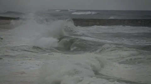 Stormy Ocean Waves Crash at Sunset: Powerful Surf on a Cloudy Beach Video stock 288687252