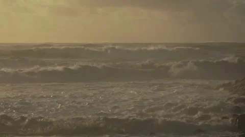 Stormy Ocean Waves Crash at Sunset: Powerful Surf on a Cloudy Beach Video stock 288687403