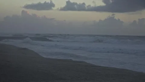 Stormy Ocean Waves Crash at Sunset: Powerful Surf on a Cloudy Beach Video stock 288687564