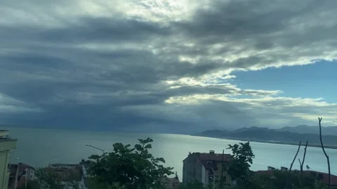 Stormy Sea and Dramatic Sunlight Over a Coastal City Between Buildings Video stock 347734480