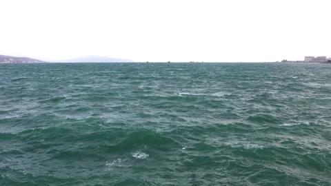 Stormy sea with powerful waves, distant city skyline and ships on the horiz.. Stock Footage 339967396