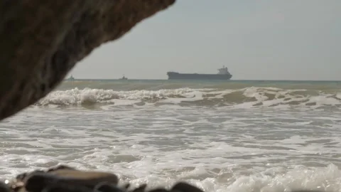 Stormy sea waves against the background of a cargo ship, a tanker sailing Stock Footage 132908307