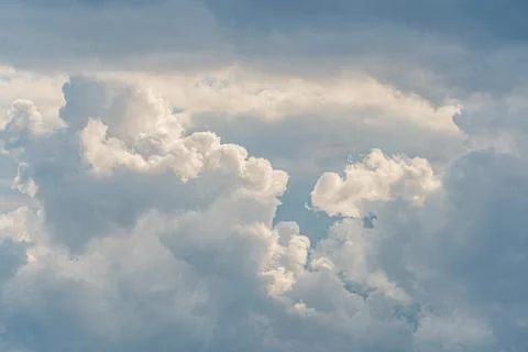 Stormy sky with dark, layered clouds and intermittent golden sunlight a Stockfoto's