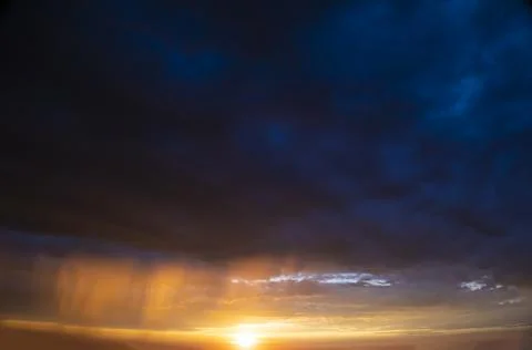 Stormy sky with dramatic clouds from an approaching thunderstorm at sunset Stock Photos