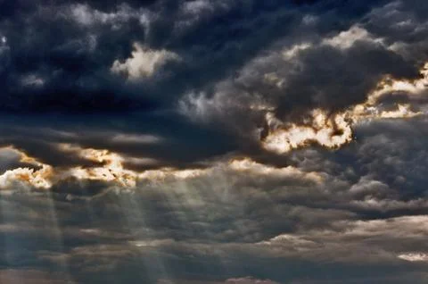 Stormy sky with a dramatic sunbeams Stock Photos