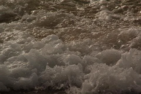 A stormy surface with waves of the sea and bubbles Stock Photos