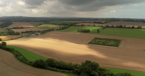 Stormy threatening rain clouds casting shadows across Devizes agricultural Stock Footage 306915300