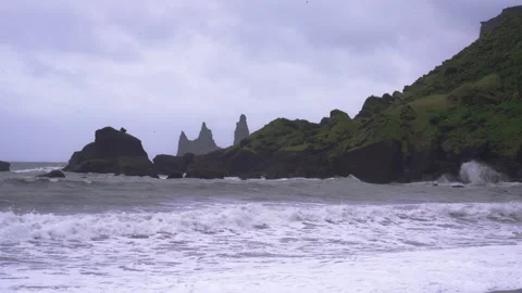 Stormy waves crash on black sand beach with jagged rocks in Vik, Iceland Video stock 327082687