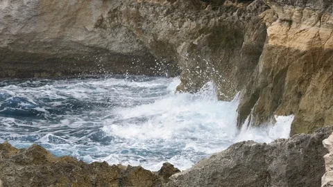 Stormy waves hitting cliffs inside a blue sea Stock Footage 108391580
