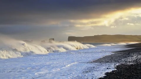 Stormy wether on the Kirkjufjara beach. View of Dyrholaey arch, south coast o Stock Footage 67095800