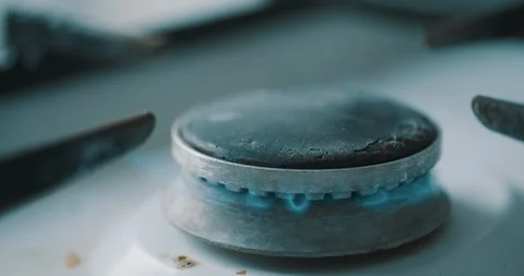 Stove burner igniting into blue cooking flame Stockbeeldmateriaal 88705436