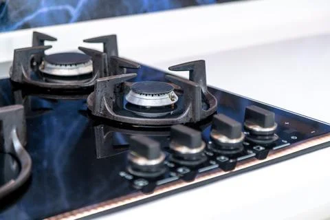 A stove with four knobs and a silver handle Stock Photos