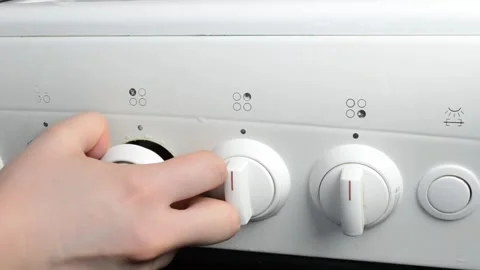 The stove has four knobs, and the knobs are white Stock Footage 303227097