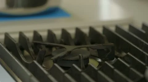 Stove ignites and pan placed on flame Stock Footage 22227104