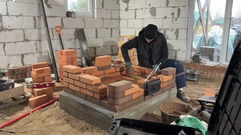 Stove maker builds a heating stove. Wide shot. Video stock 322961420