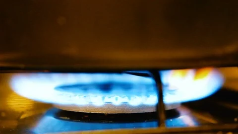 Stove under a pot with flame that lights up in slowmotion Video stock 86327559