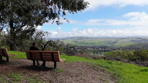 STP2_Flying over a hill passing someone sitting on a bench looking at the view Stock Footage 118852182