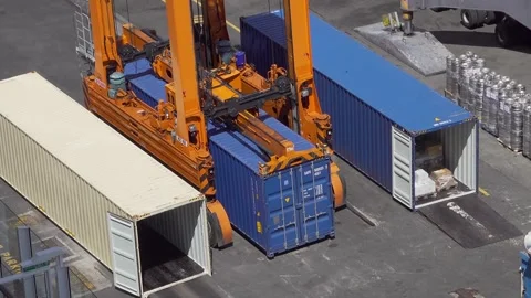 A straddle carrier moves a shipping container, Barbados docks Stock-Footage 304123802