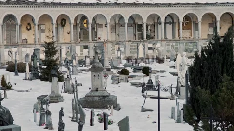 Straight classical colonnade and snow-covered graves in a historical monumental Stock Footage 329309499