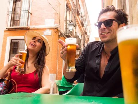 Straight couple laughing drinking beer on a bar terrace Fotos Stock