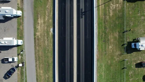 Straight-down aerial view of an empty drag strip with twin lanes bordered by Stock Footage 346147295