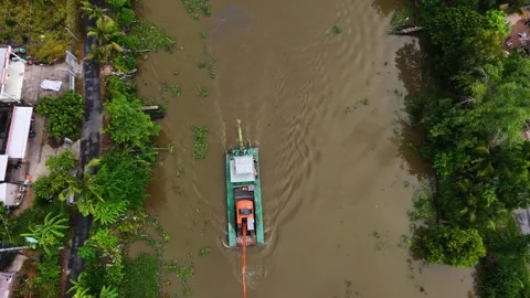 Straight down aerial view of excavator self-propelling on muddy waterway Stock Footage 341229700