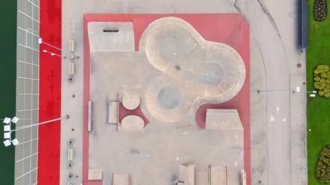 Straight-down drone view of a large concrete skatepark with sculpted bowls and Video stock 347914533
