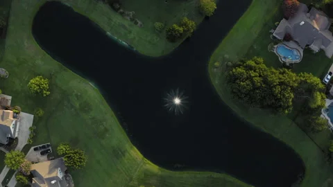 Straight down rotating aerial over large neighborhood pond with fountain Stock Footage 248080558