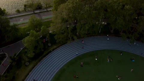 Straight Down on Running Track, Tilt Up Reveal of East River &amp; RFK Bridge Drone Stock Footage 165245822