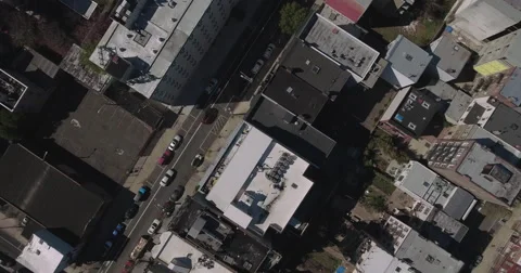 Straight down on tar roofs, rear yards and a narrow street Видео 62442207