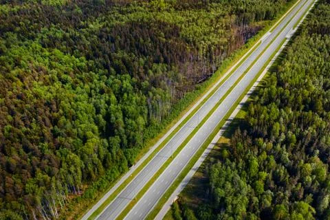 Straight empty highway through deep forest aerial view Stock-Fotos