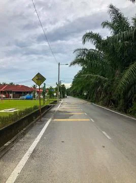 Straight empty road with cloudy sky. Selective focus Stock Photos