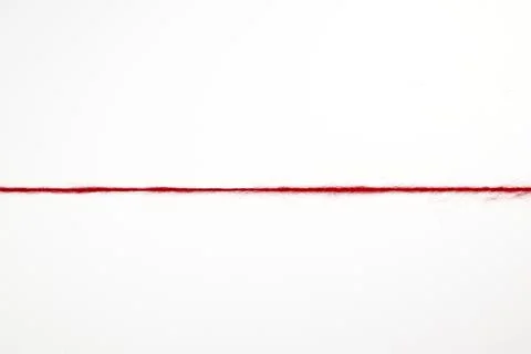 A straight line of red woolen threads on a white background Stock Photos