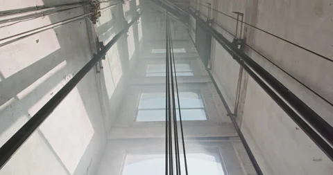 Straight on low angle tilt down a freight elevator shaft. Video stock 138608308