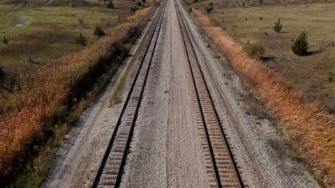 Straight parallel train tracks under clear blue sky, tilt up. Stock Footage 260179084