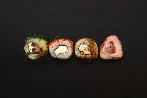 Straight parallel vertical lines of sushi and chopstick on black background. 库存照片