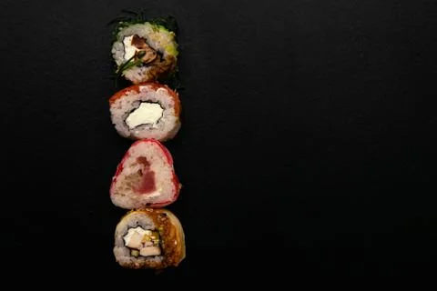 Straight parallel vertical lines of sushi and chopstick on black background. 库存照片